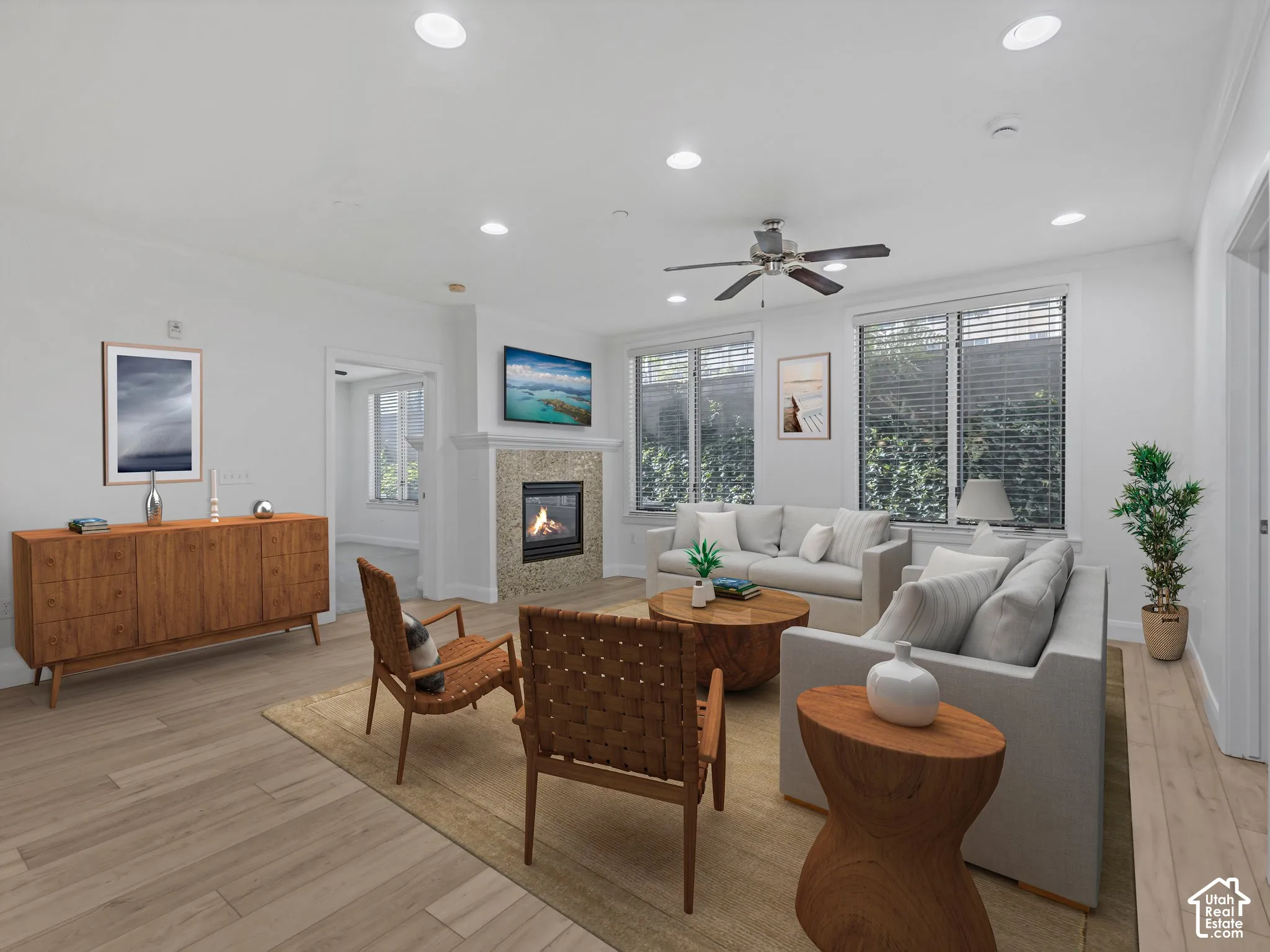 Spacious living area featuring light wood-finish flooring, recessed lighting, and a ceiling fan
