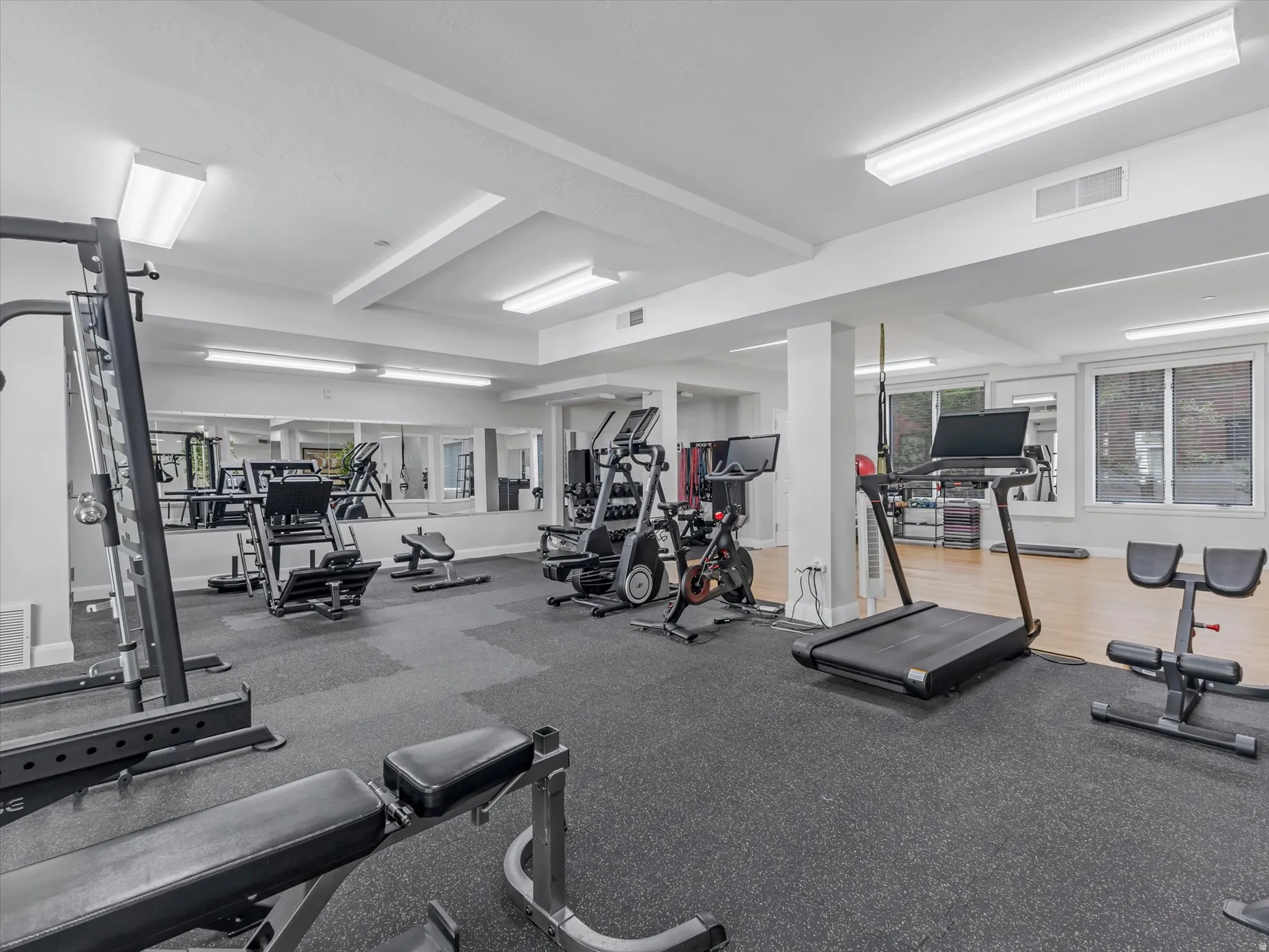 Fitness room featuring a rubberized flooring system and mirrored walls