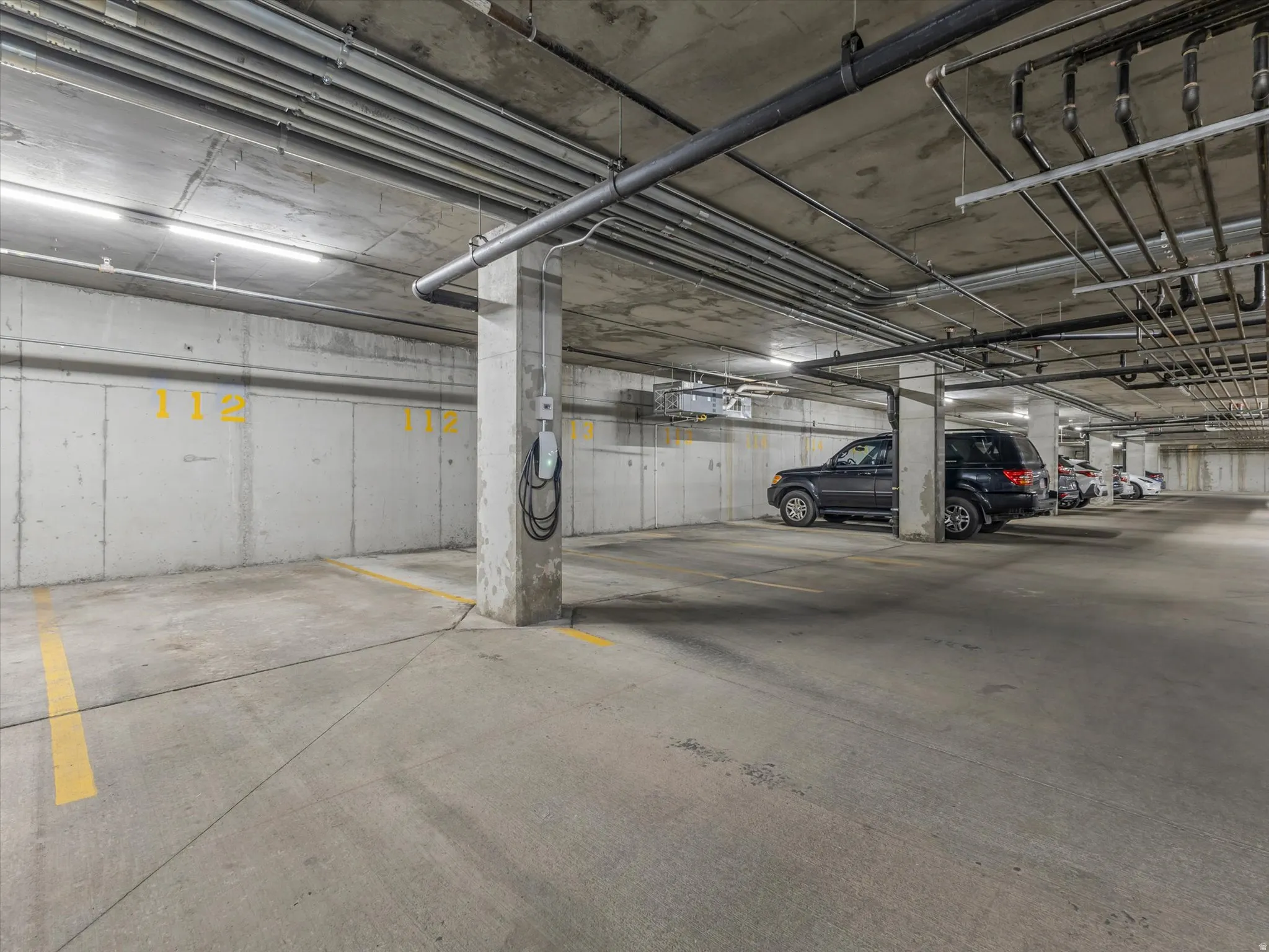 Concrete parking garage with dedicated parking space and electric vehicle charging station