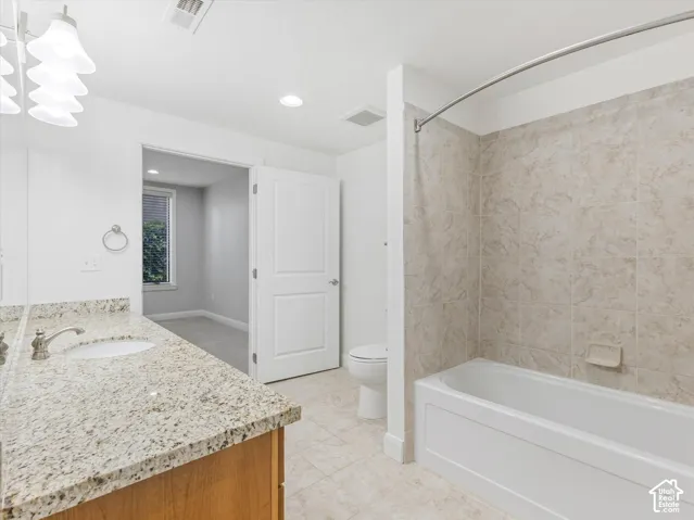 Bathroom featuring a vanity with a light-toned granite countertop and an undermount sink