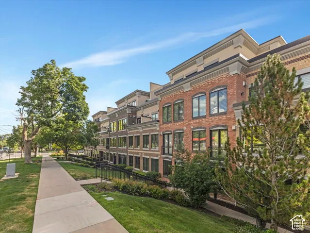 Brick and stucco facade townhouse featuring a multi-story design with prominent windows