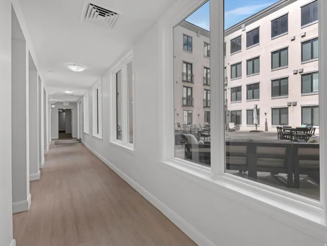 Hallway featuring wood-finish flooring, recessed lighting, and white trim