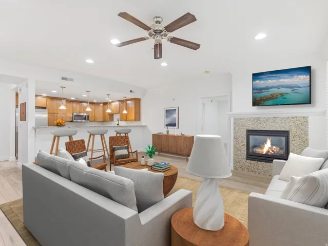 Living area featuring a fireplace with a stone surround and a white mantel