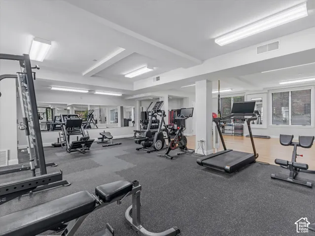 Fitness room featuring a rubberized flooring system and mirrored walls