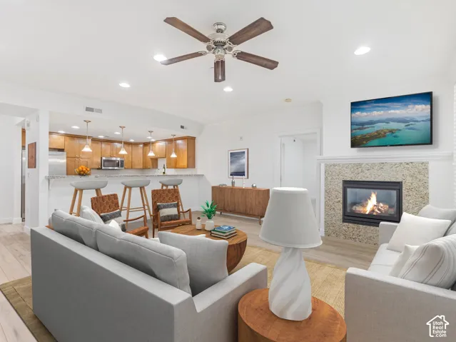 Living area featuring a fireplace with a stone surround and a white mantel