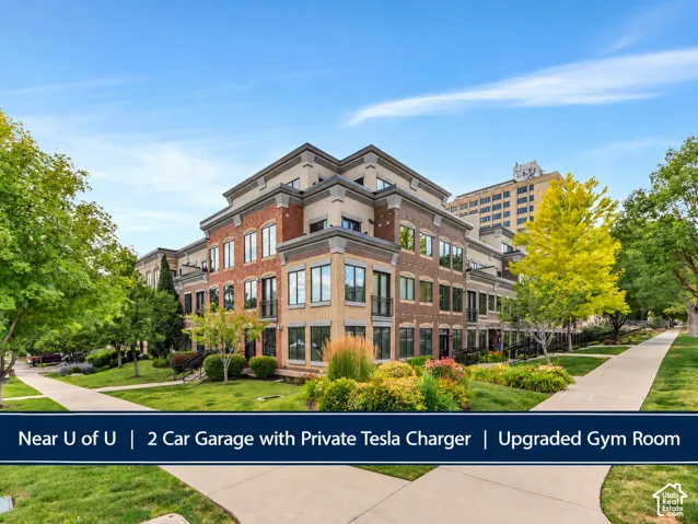 Multi-level townhouse with brick and stone facade, large windows, and integrated balconies
