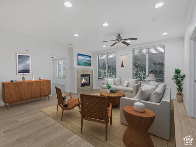 Spacious living area featuring light wood-finish flooring, recessed lighting, and a ceiling fan