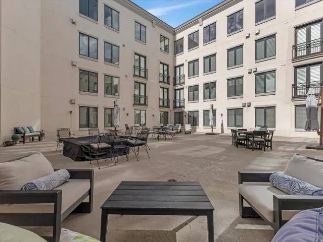 Expansive courtyard with concrete surfacing surrounded by a multi-story building