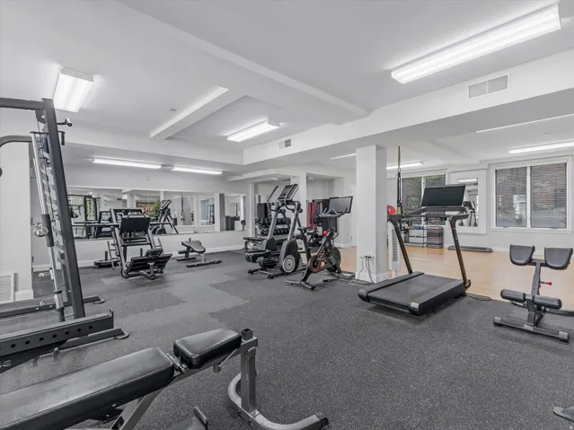 Fitness room featuring a rubberized flooring system and mirrored walls
