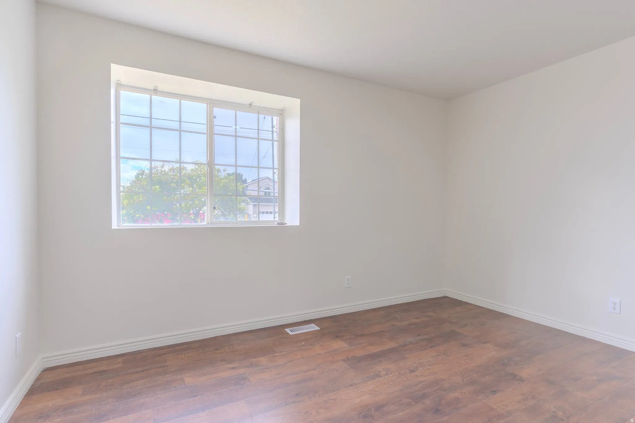Bright interior space featuring wood-finish flooring, white walls, and white trim