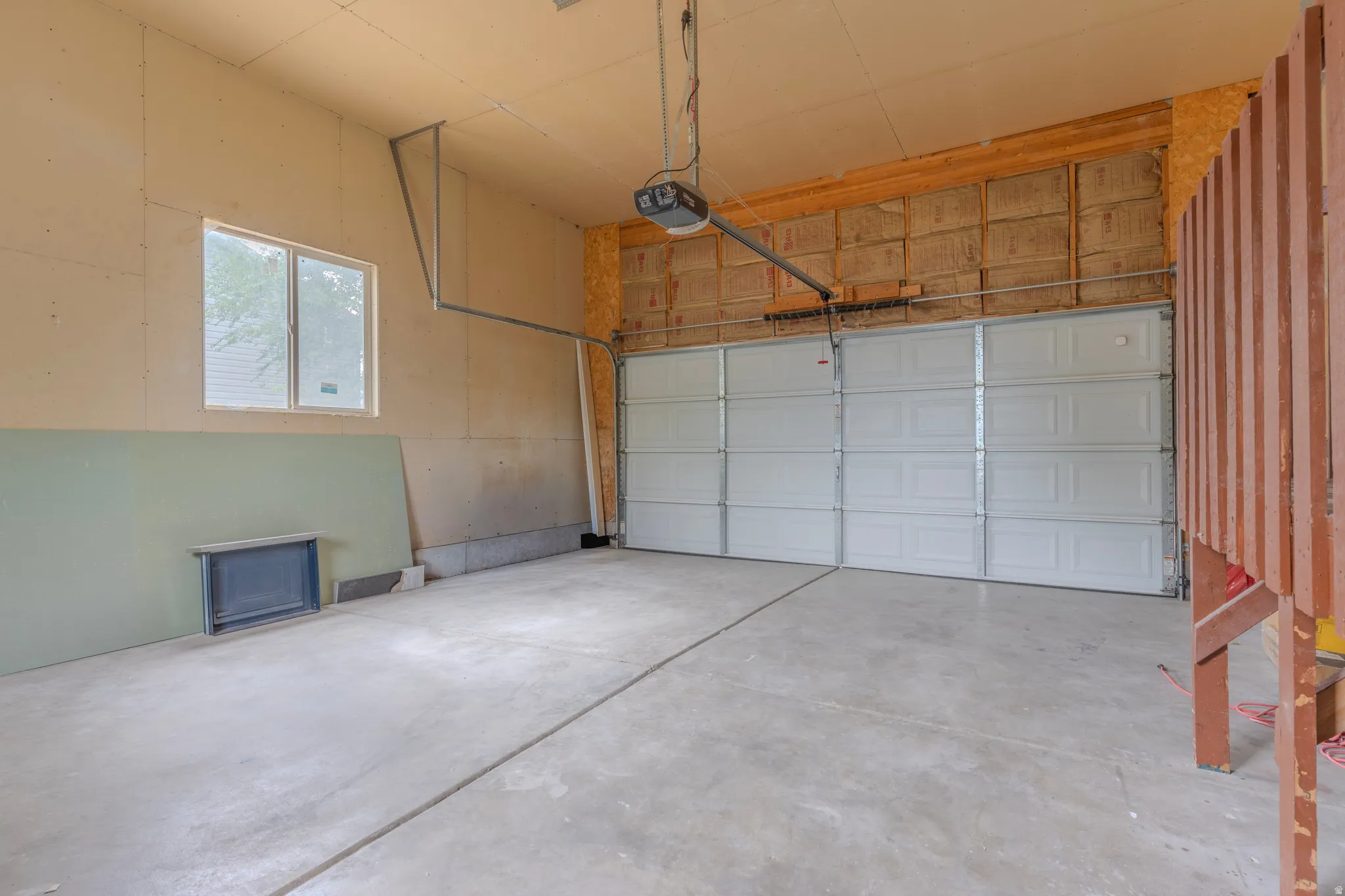Spacious garage with a sectional overhead door and concrete flooring