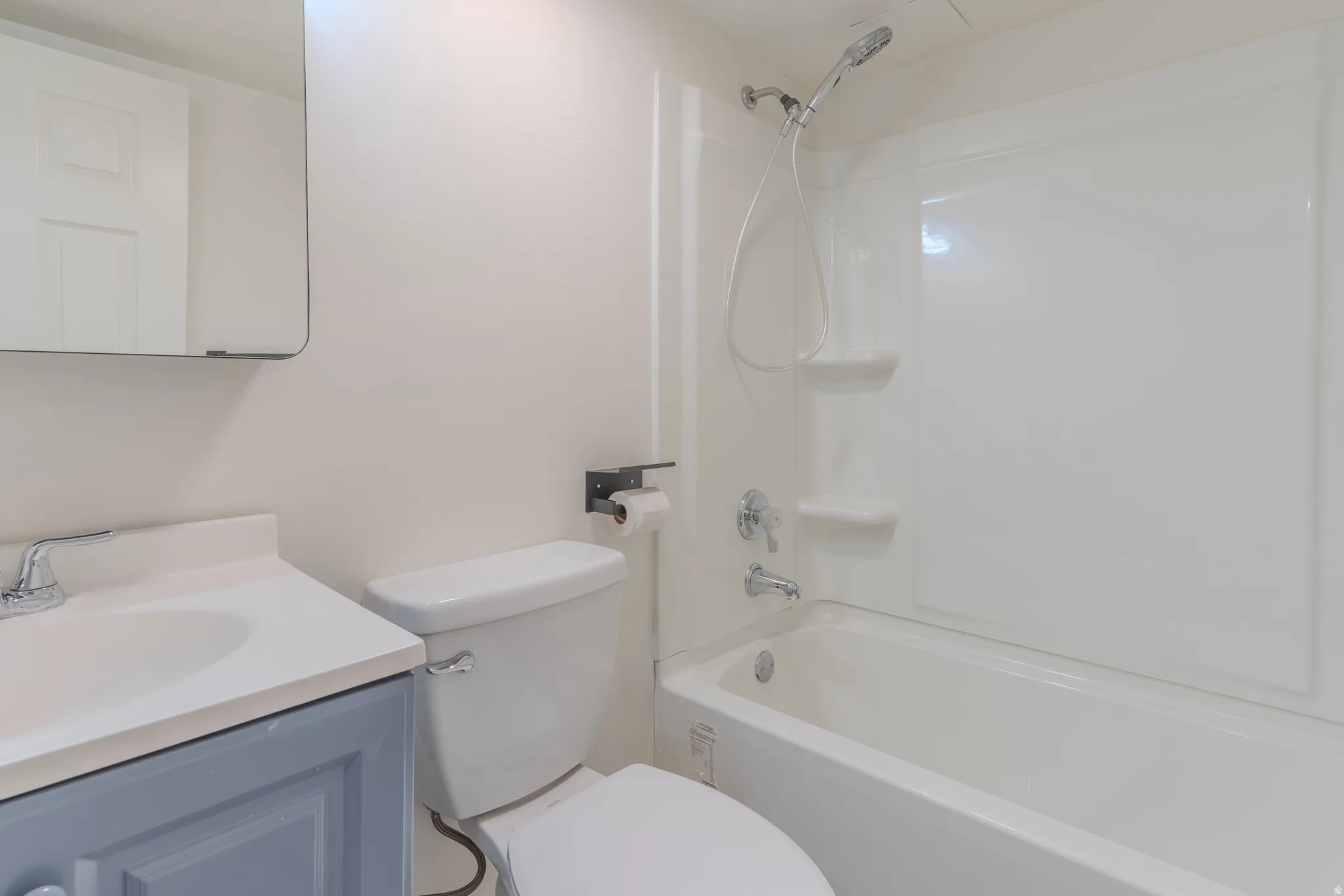 White bathtub with an integrated shower head and wall-mounted shelving