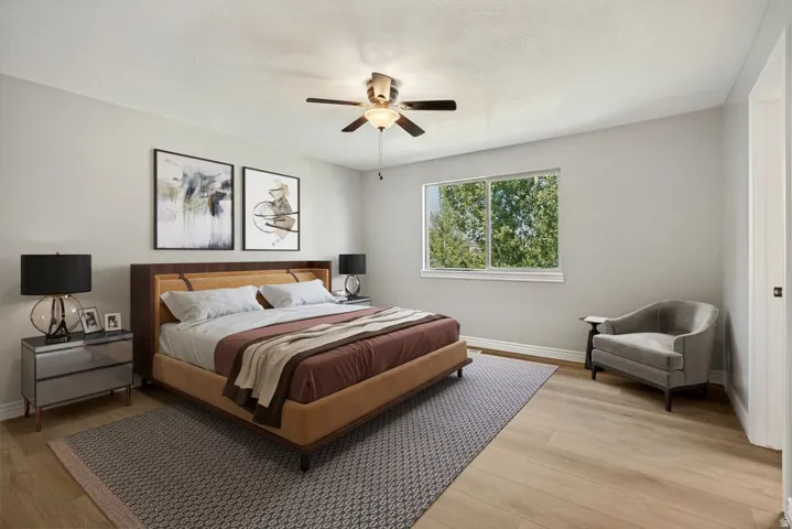 Expansive room featuring light wood-finish flooring, a large window, and a ceiling fan with integrated lighting