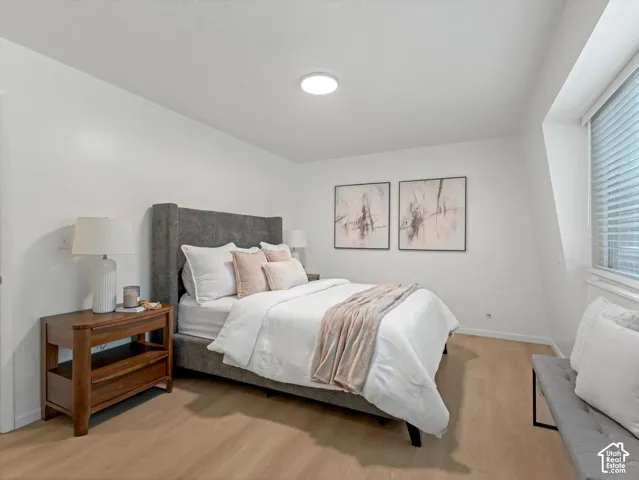 White walls, light wood-finish flooring, a window with blinds, and recessed lighting