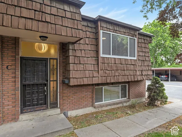 Exterior facade featuring brown shingle siding and brick detailing