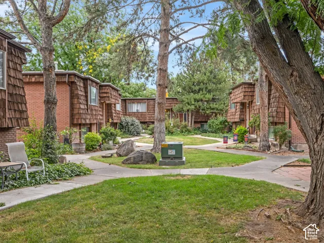 Central courtyard featuring a manicured lawn, established trees, and concrete pathways