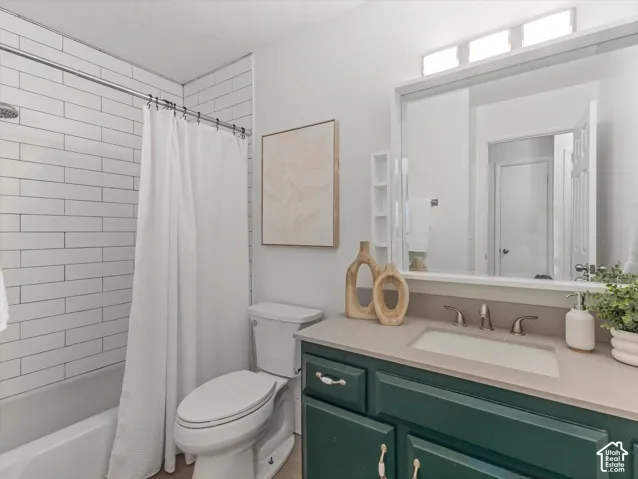 Bathroom featuring a white subway tile shower, built-in tub, vanity with a light-colored countertop, integrated sink, and an overhead lighting fixture