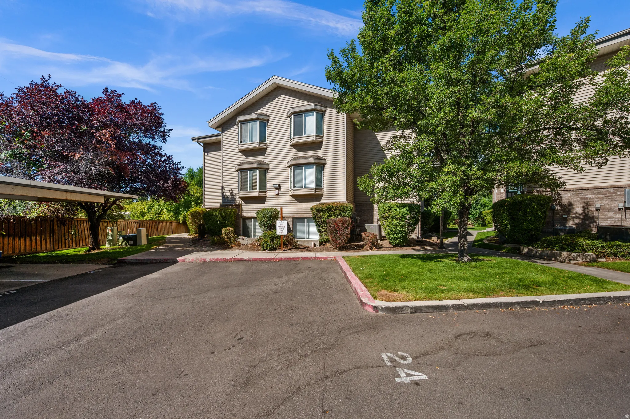 Multi-level exterior with siding, bay windows, and mature landscaping