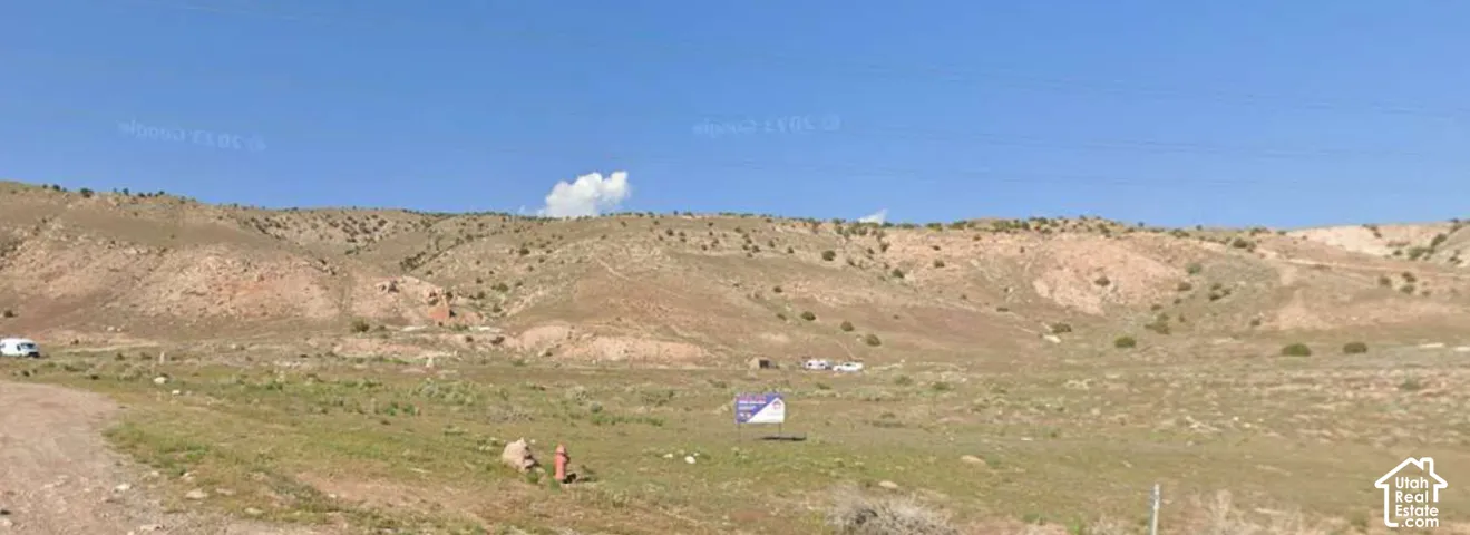 Expansive land parcel featuring natural terrain and distant hillsides