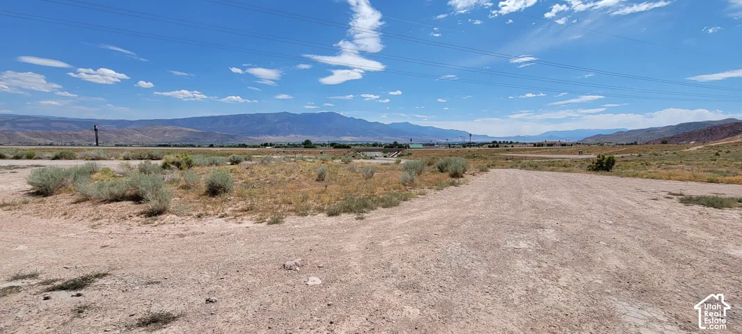Expansive desert terrain with distant mountain ranges under a clear sky
