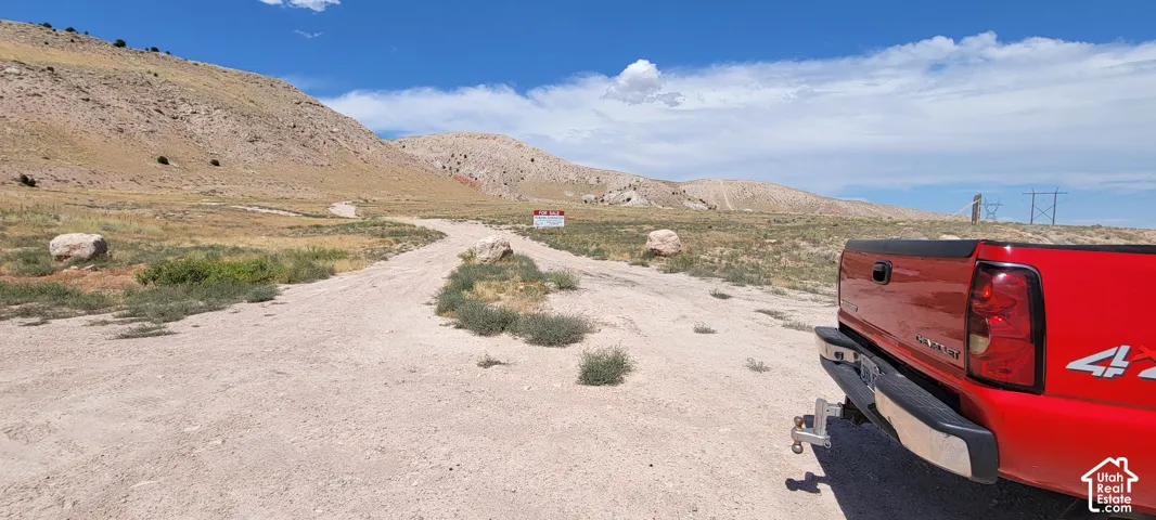 Expansive unpaved terrain with a prominent hill backdrop