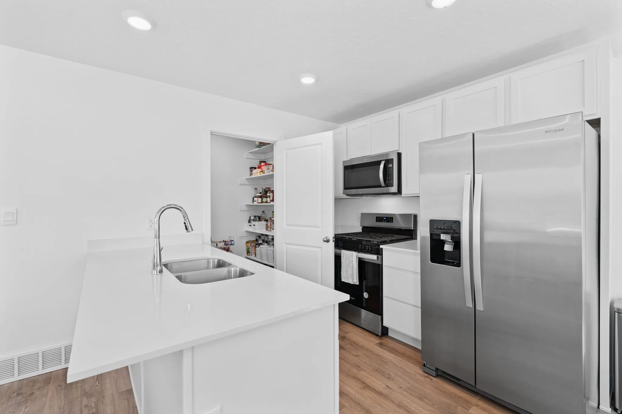 Kitchen. Stainless Steel Appliances. White Cabinets. Quartz tops. Gorgeous warm solid surface flooring. Large windows! Can lights. Beautiful white walls. Bright! Open Concept!