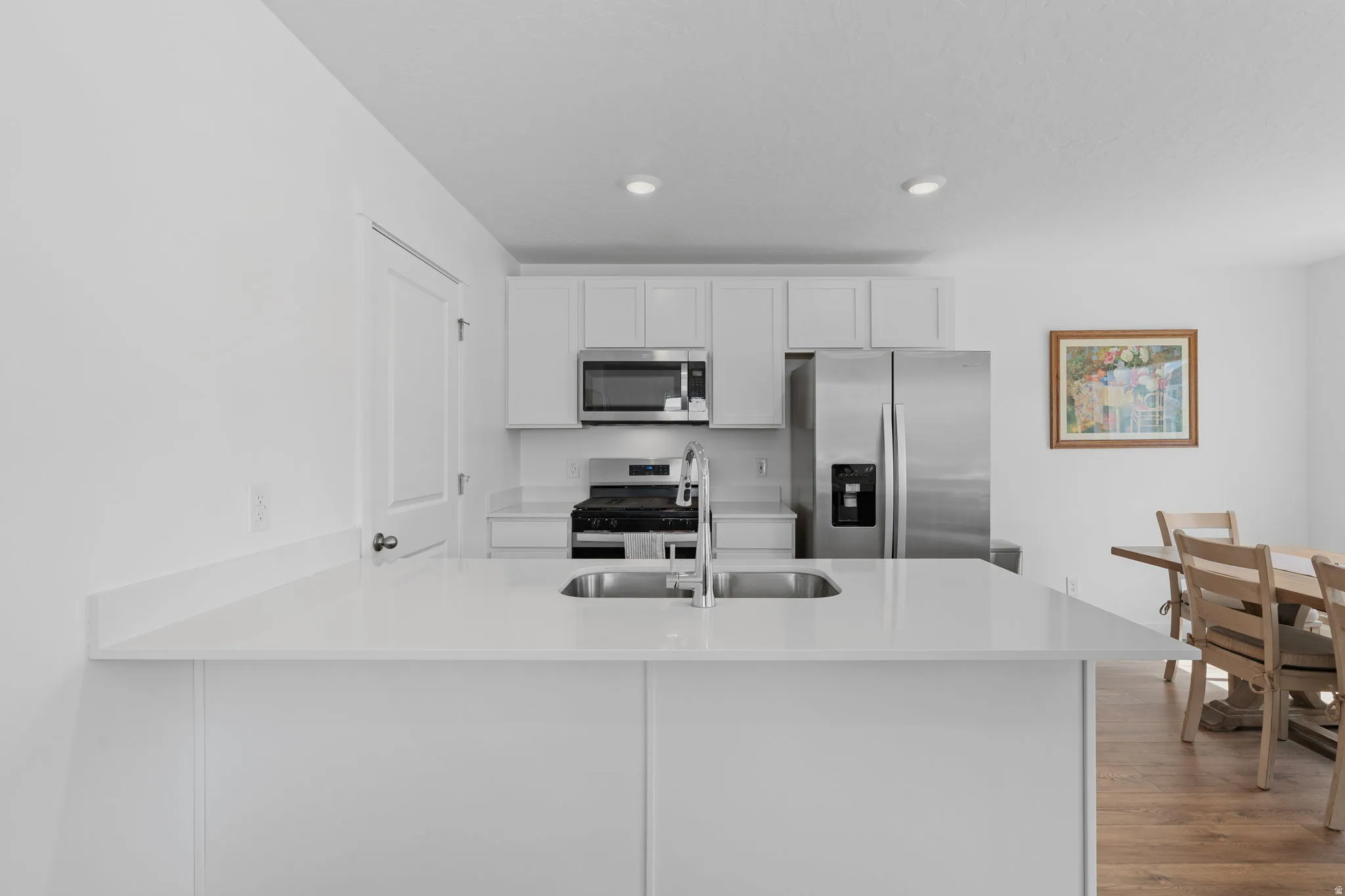 Kitchen. Stainless Steel Appliances. White Cabinets. Quartz tops. Gorgeous warm solid surface flooring. Large windows! Can lights. Beautiful white walls. Bright! Open Concept!