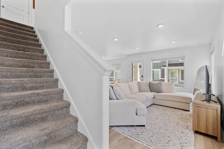 Entryway. Stairs to 2nd level. Gorgeous warm solid surface flooring. Large windows! Can lights. Beautiful white walls. Bright! Open Concept!