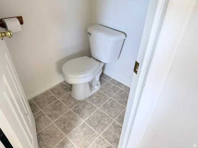 Tile flooring and a white toilet