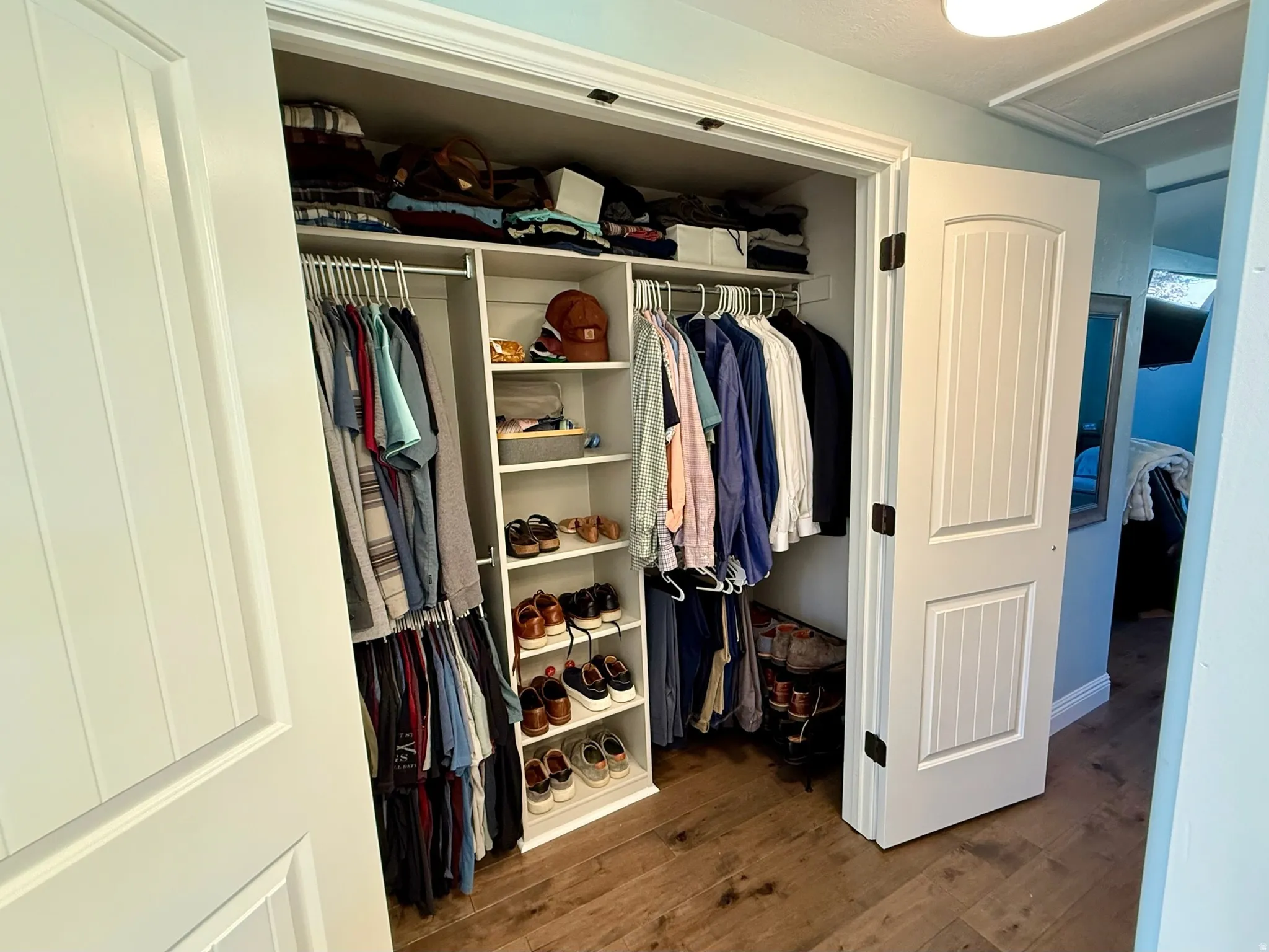 2nd master closet-Custom closet organization system featuring white shelving and multiple hanging rods