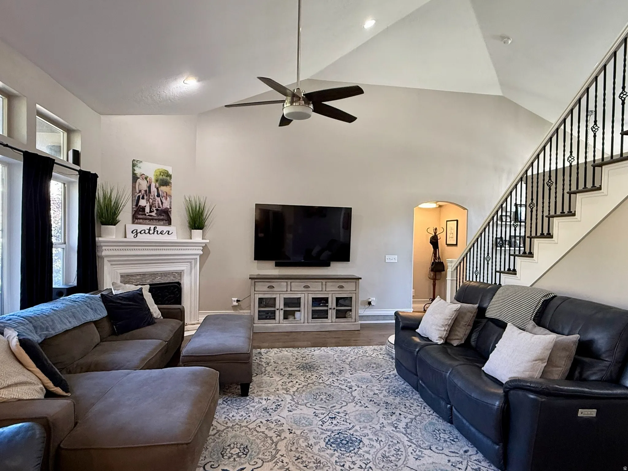 Vaulted ceilings enhance this living area featuring a fireplace with a detailed white mantel