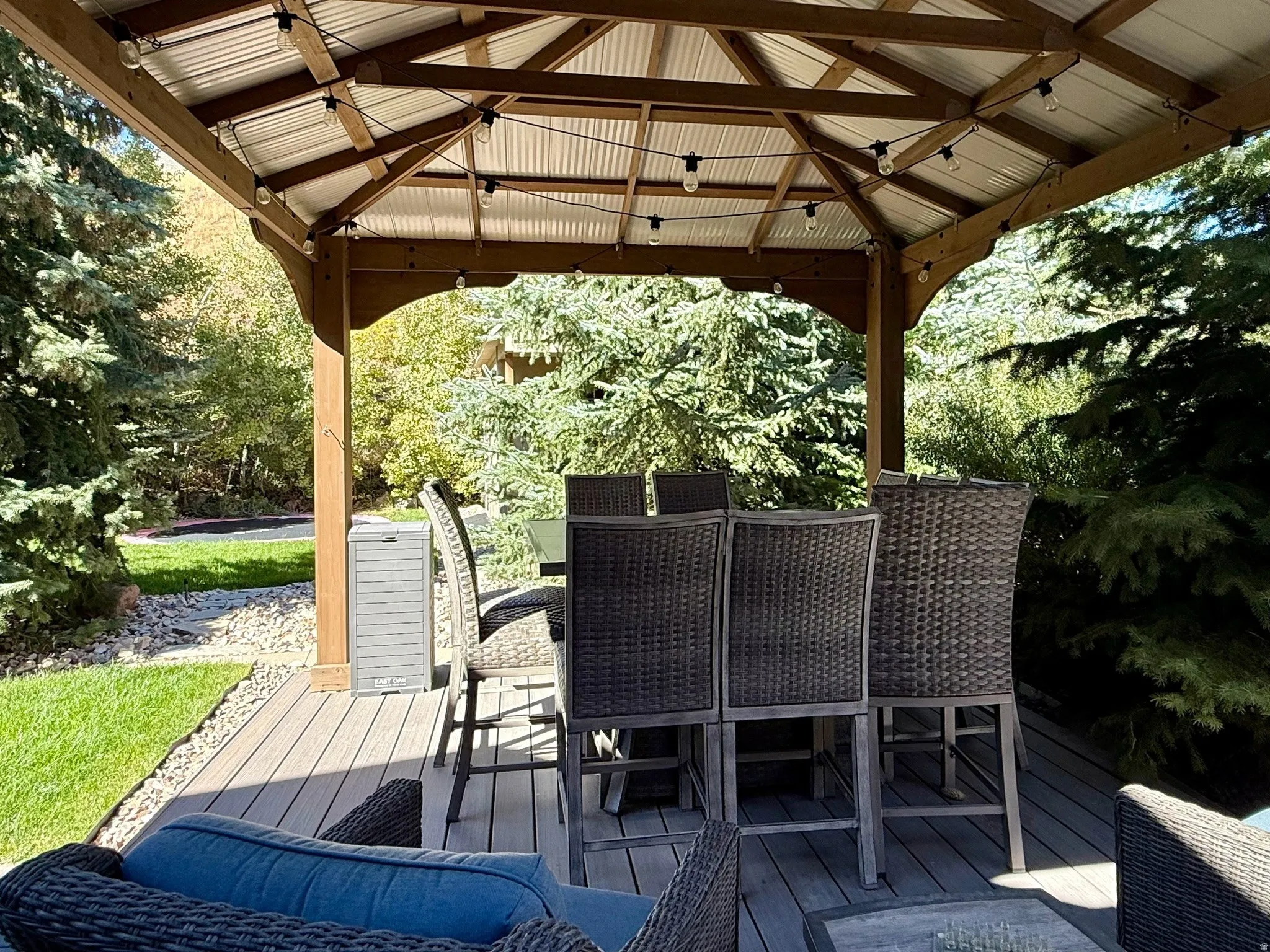 Covered outdoor living space featuring a wood-frame gazebo with a corrugated metal roof