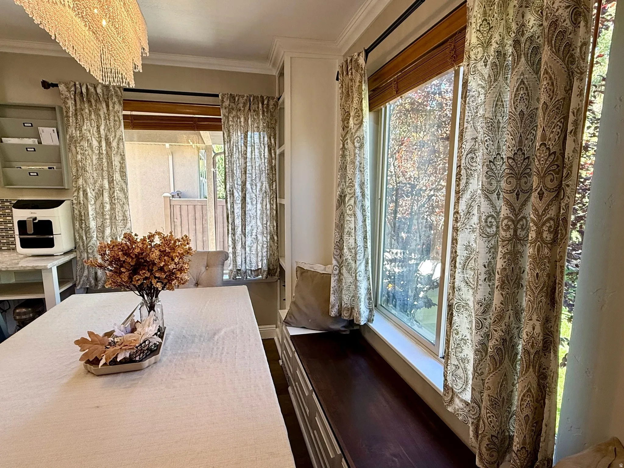 Dining area featuring a crystal chandelier and large windows with wood blinds