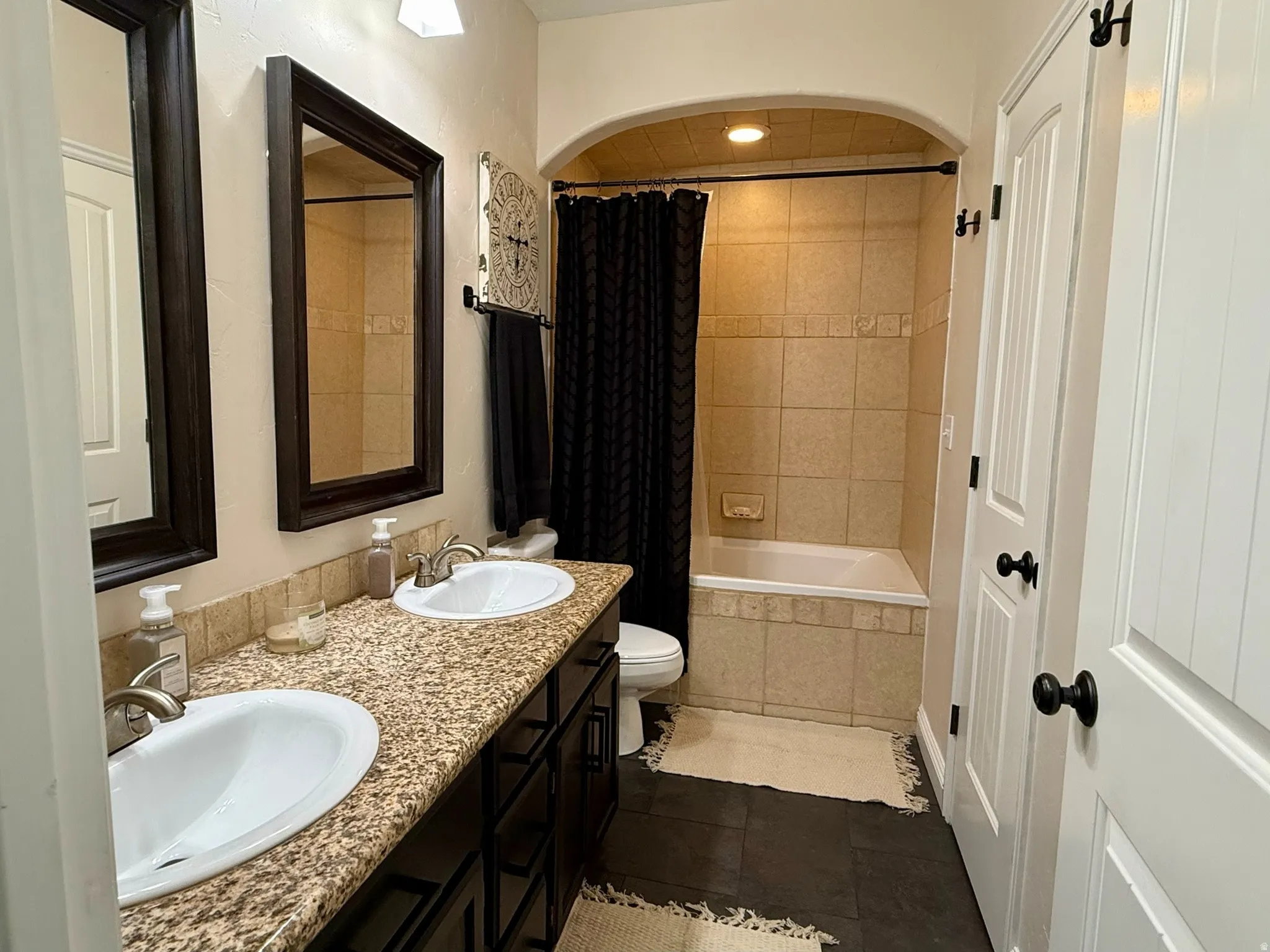Dual vanity featuring a speckled countertop and undermount sinks