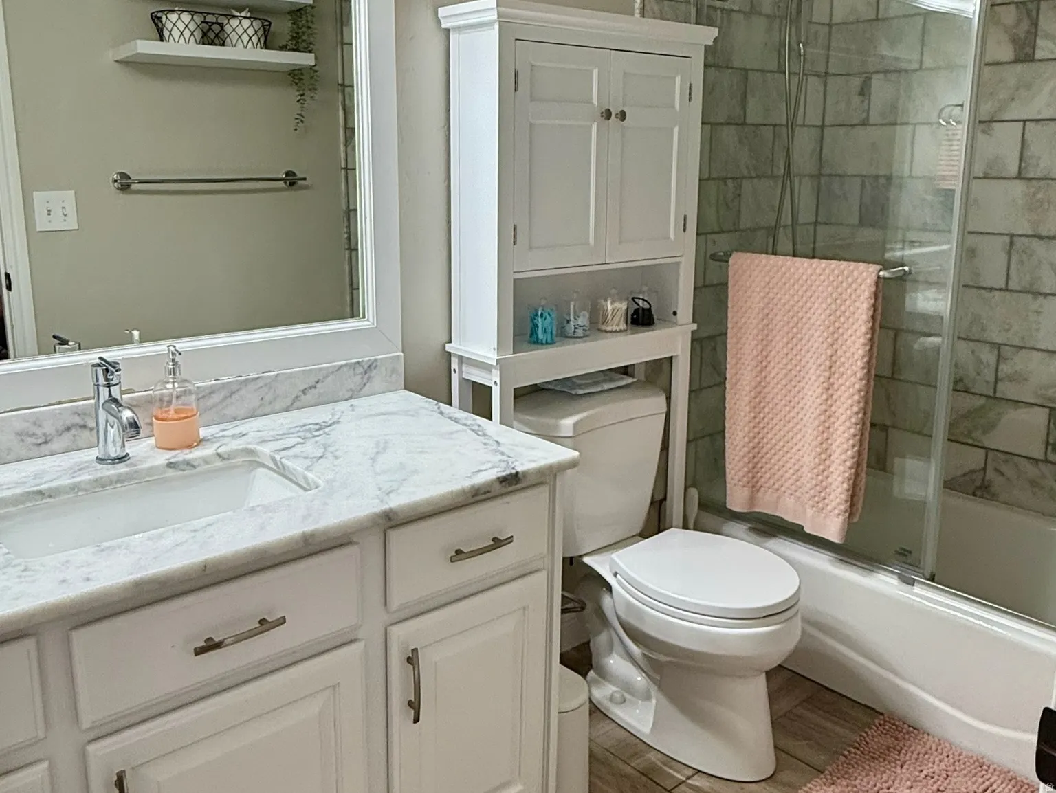 Bathroom featuring a white vanity with a marble-finish countertop and undermount sink