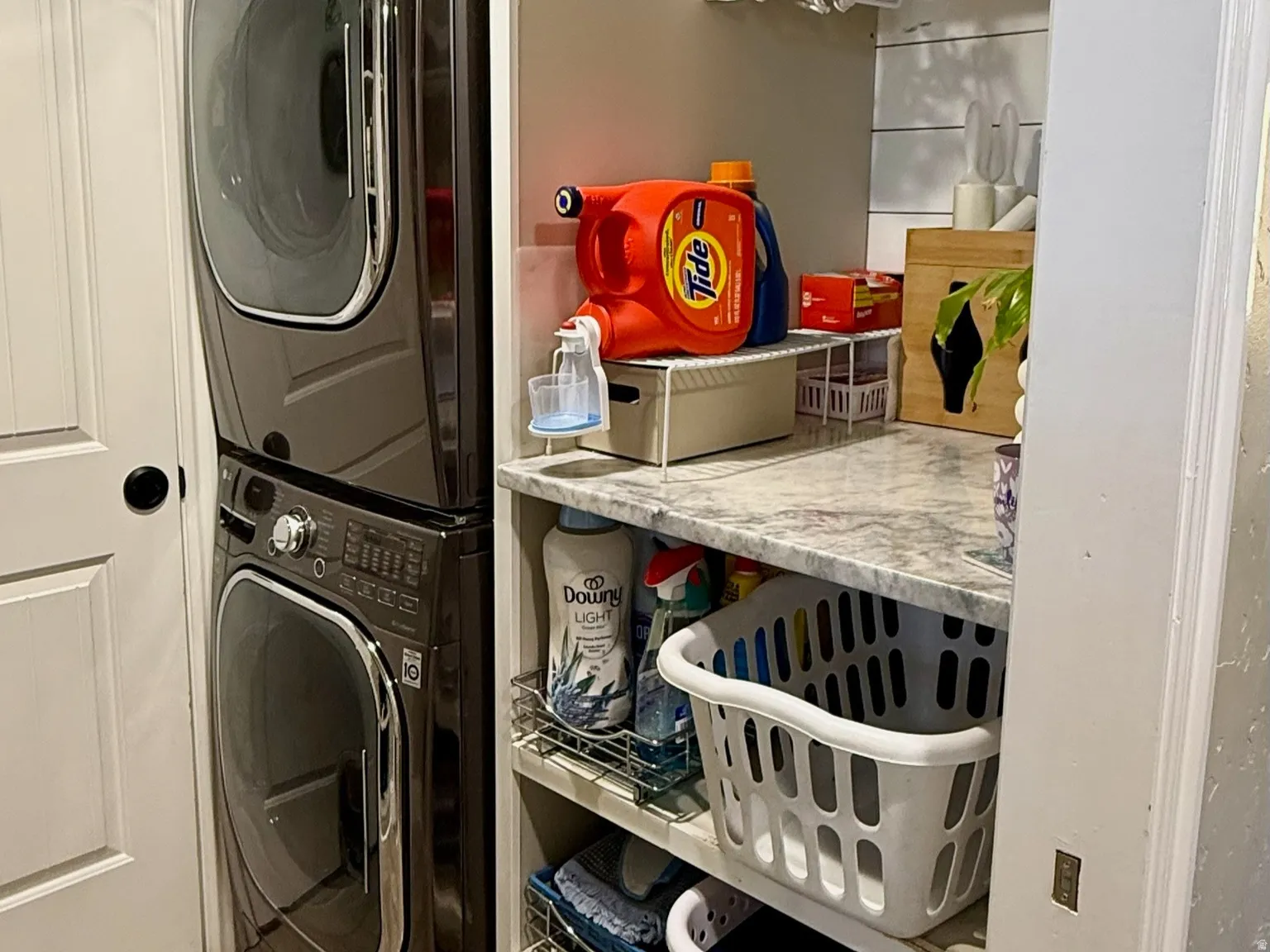 Dedicated laundry area featuring wood-finish tile flooring and stacked appliances