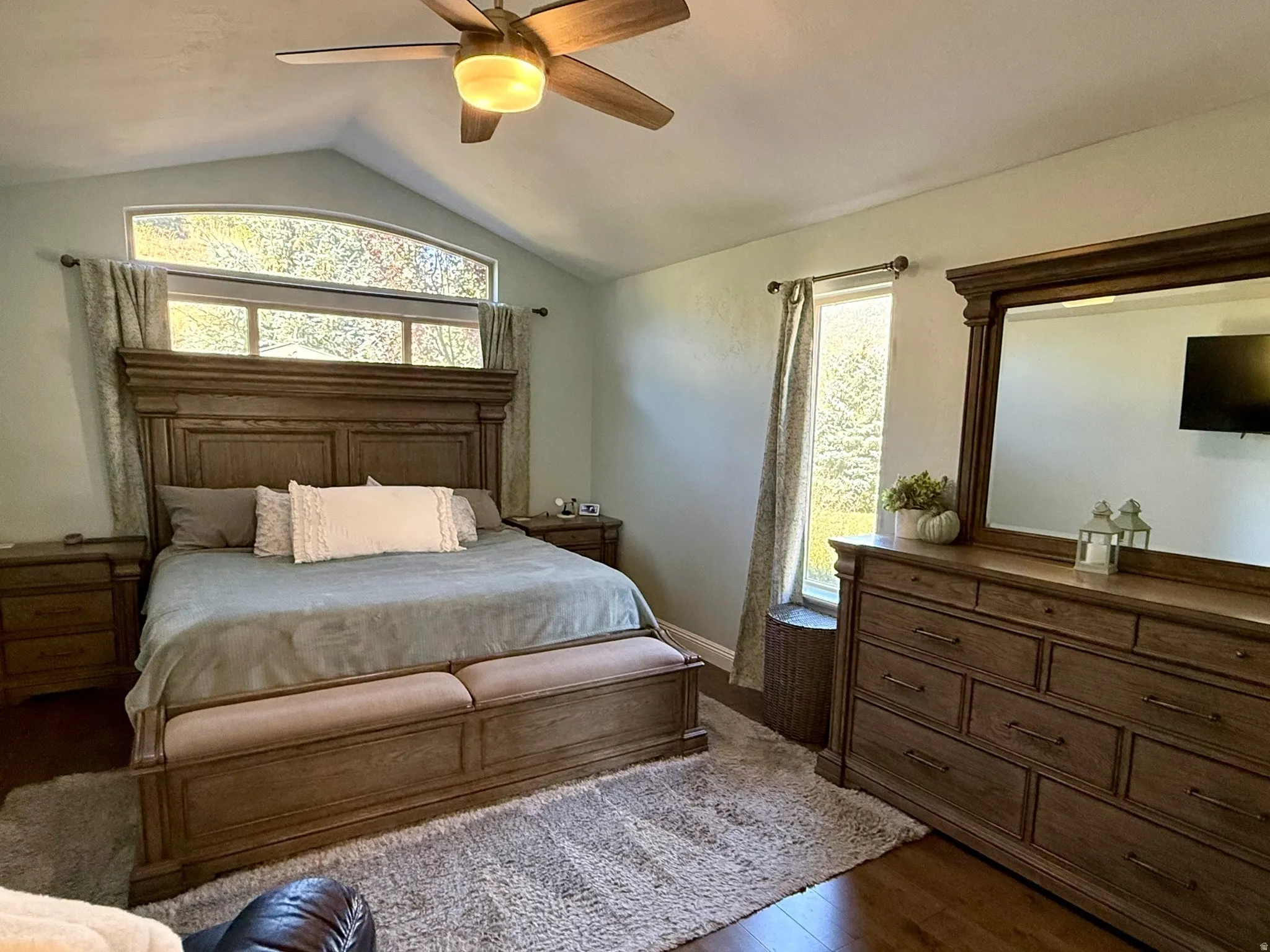 Vaulted ceiling with a wood-finish ceiling fan and integrated lighting