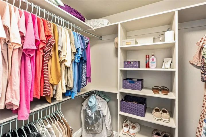 Primary Suite Closet- Built-in closet shelving with multiple storage levels and hanging rods