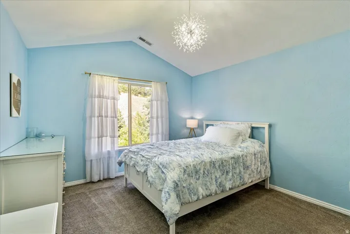 Vaulted ceiling, recessed window, wall-mounted light fixture, carpeted flooring, built-in dresser