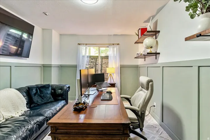 Accent wall with wainscoting detail, ceiling-mounted lighting, and wood-finish floating shelves
