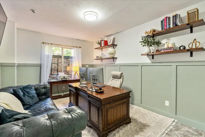 Board and batten wall paneling, built-in open shelving, recessed lighting, and a large window