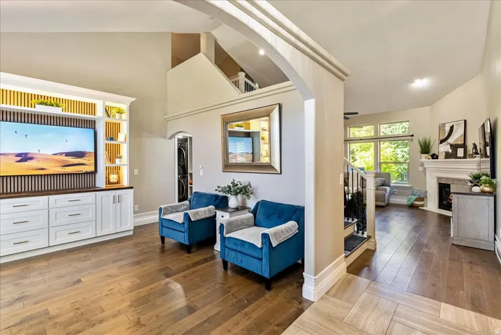 Wood-finish flooring throughout, custom built-in media center with wood accents, and vaulted ceilings