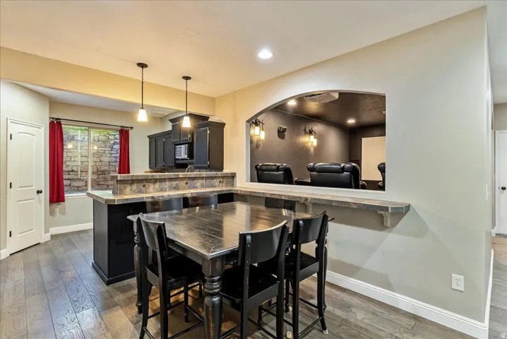 Kitchen featuring dark wood cabinetry, a built-in microwave, and pendant lighting