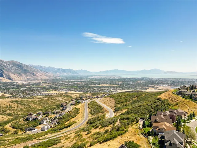 Expansive mountain range backdrop with a distant body of water
