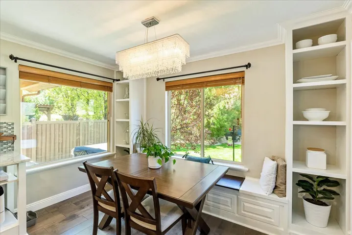 Hardwood-finish flooring, built-in shelving, built-in window bench, large windows, and a rectangular chandelier