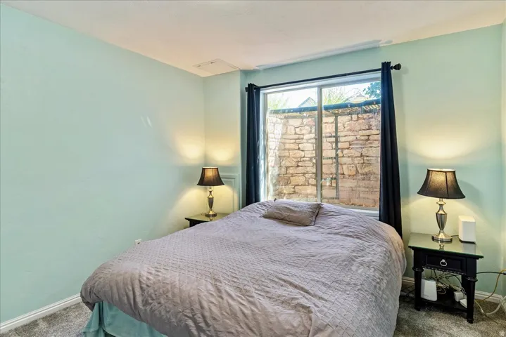 Recessed window with a stone wall backdrop, light-toned walls, and carpet flooring