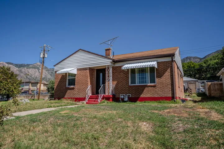 Brick exterior with white siding accents and a brown shingle roof