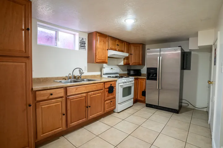 Kitchen featuring wood-finish cabinetry, tile flooring, and stainless steel refrigerator