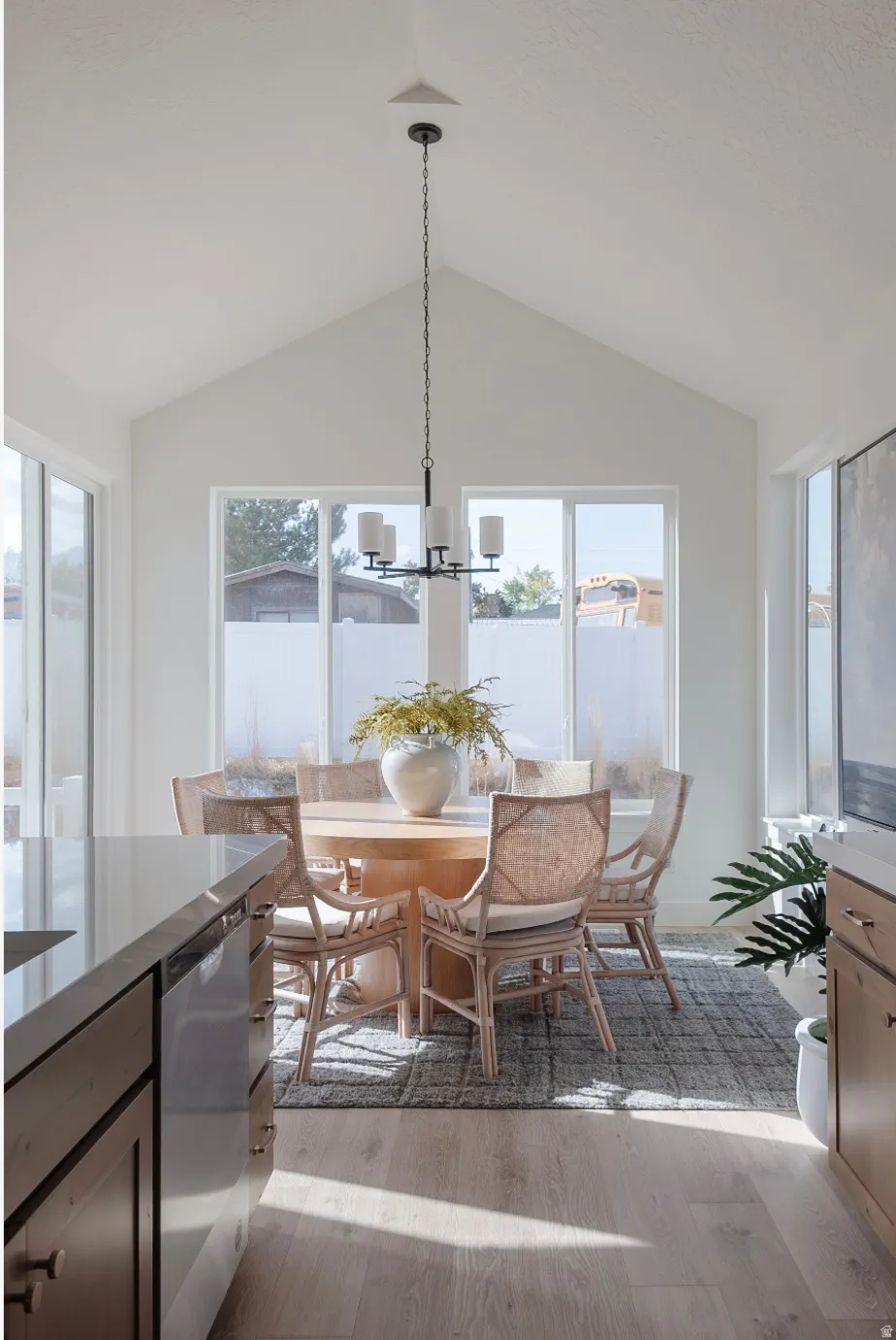 Dining area featuring a vaulted ceiling and a contemporary chandelier