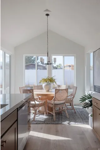 Dining area featuring a vaulted ceiling and a contemporary chandelier